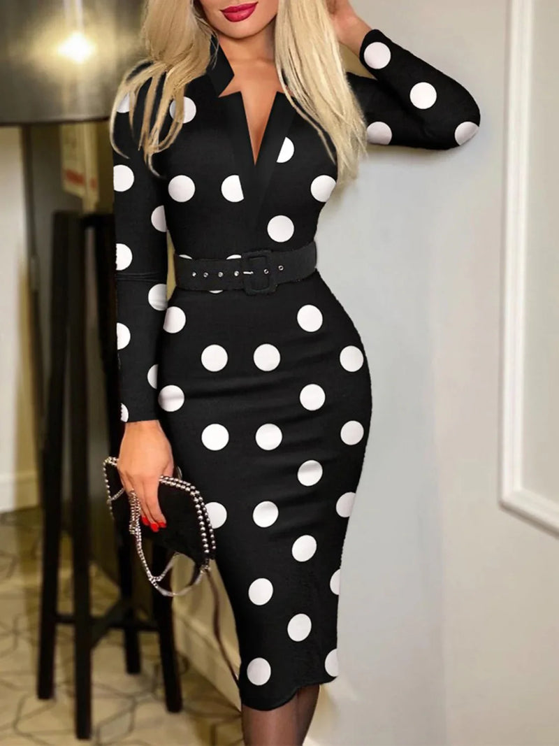 Woman wearing a dot wrap midi dress with ankle boots and a crossbody bag on a sunny street