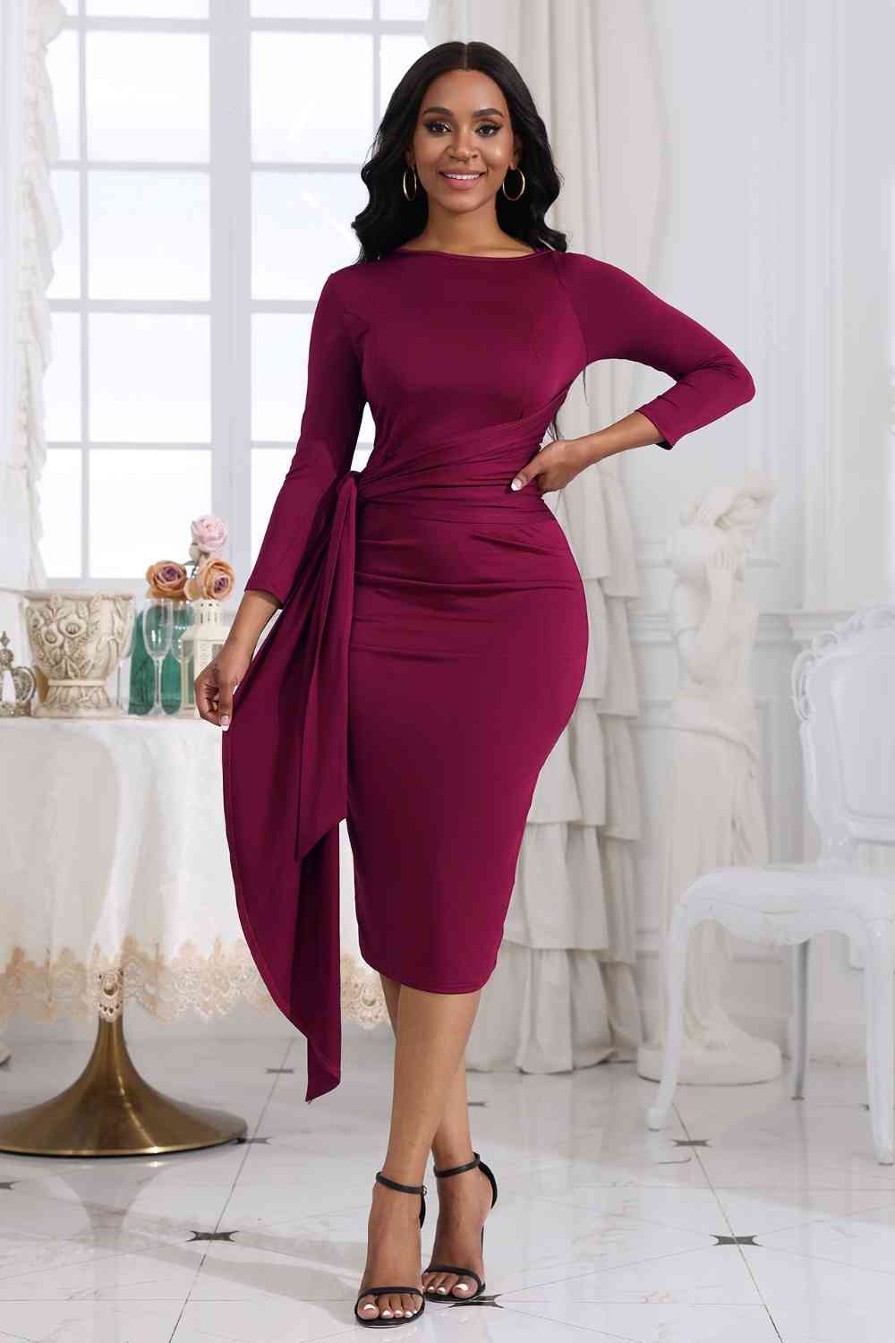 Woman wearing a Tie Detail cocktail midi dress at a holiday party